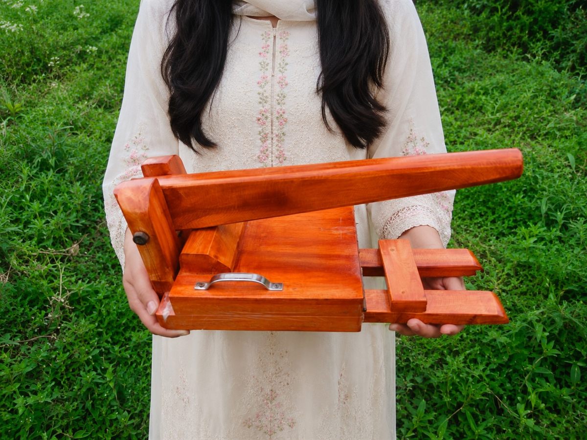 হাতে ধরা কাঠের রুটি মেকার — আকার বোঝা যাচ্ছে