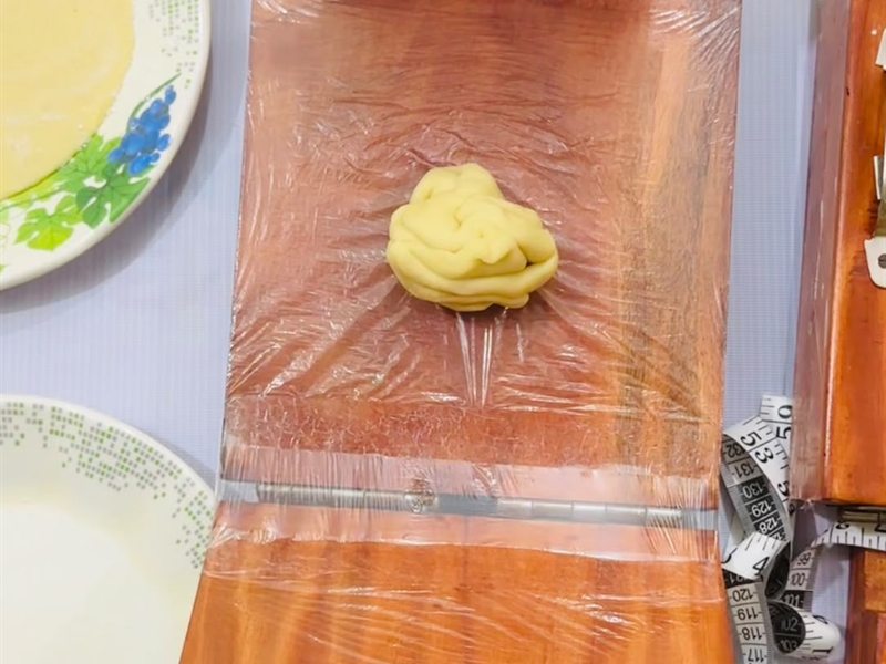 প্রেসের মাঝখানে আটার গোলা রাখা হচ্ছে